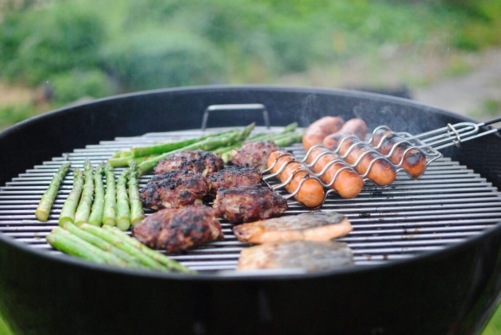 Grilling burgers and hot dogs is a cheap main dish addition to a Fourth of July meal plan.