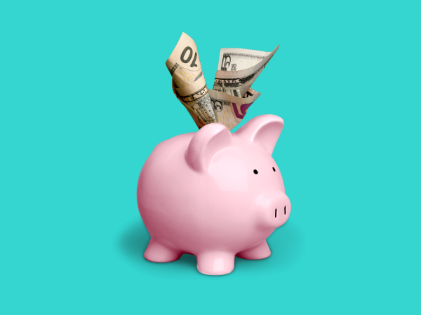 This bright teal background features a stuffed pink piggy bank. Frugal living can help you save more money, as this pink piggy bank with cash sticking out of the top displays.